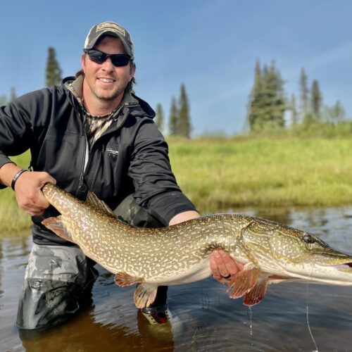 Dallis Joiner poses with a large fish while standing in a river. This Terry PMBA student has startd an Outdoor adventure club Atlanta