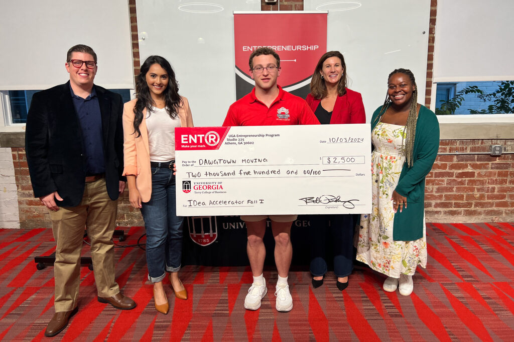 Savannah native Clay Proper poses with a novelty check for $2500 and UGA Idea Accelerator judges at Studio 225.