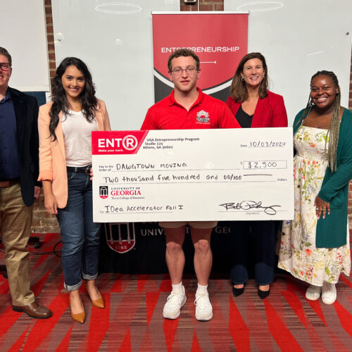 Savannah native Clay Proper poses with a novelty check for $2500 and UGA Idea Accelerator judges at Studio 225.