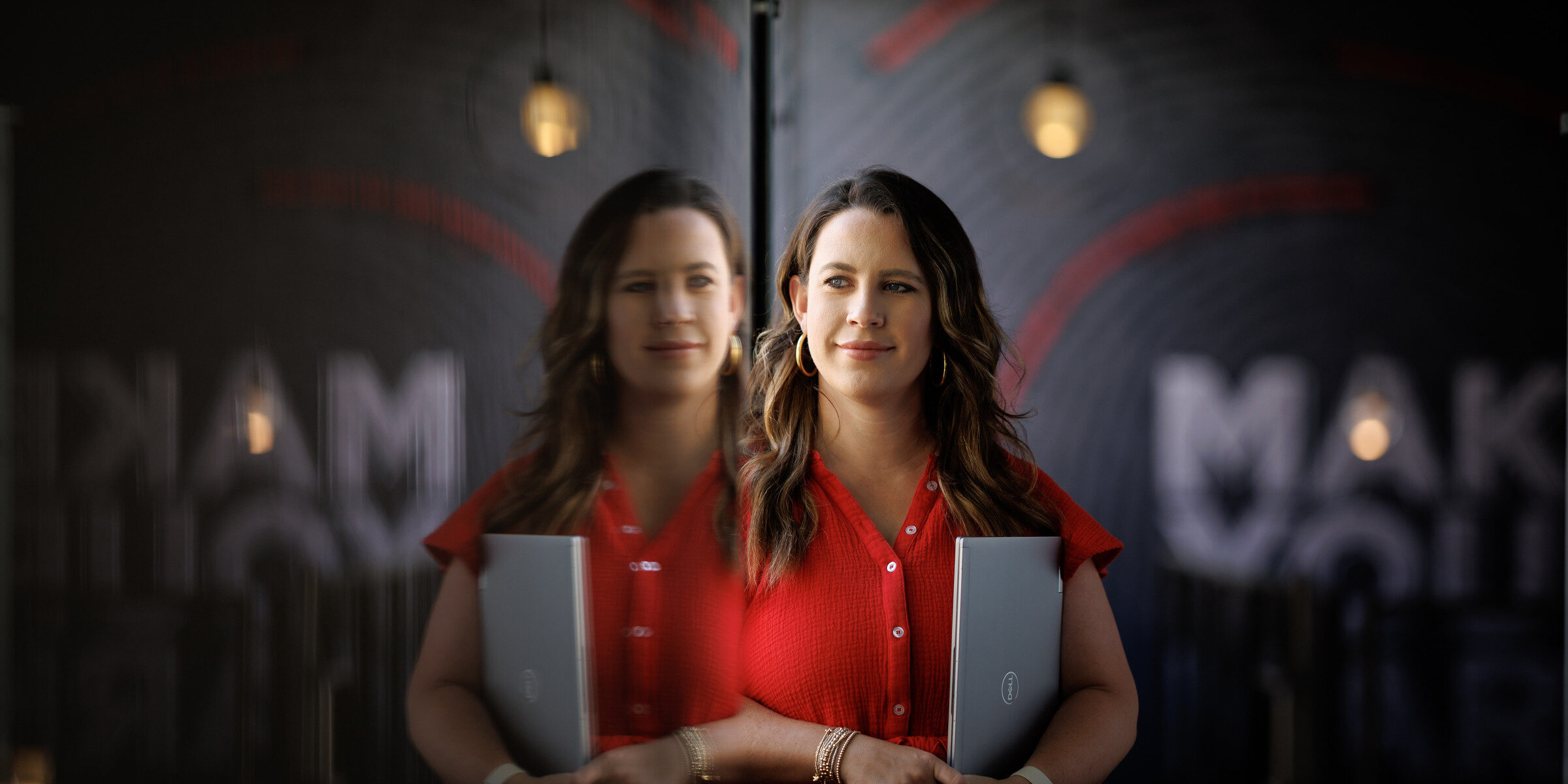 Woman in red holding laptop