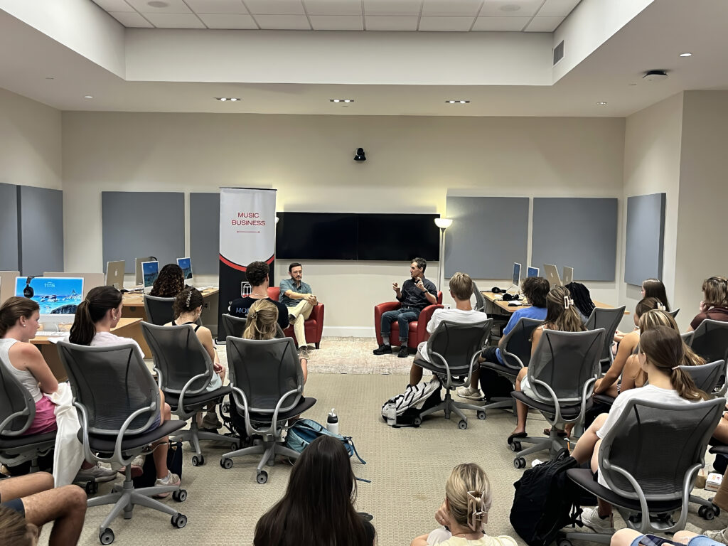 Students pack into a lab classroom in rolling chairs to watch a visiting speaker. Emmet Beliveauv from C3 Presents