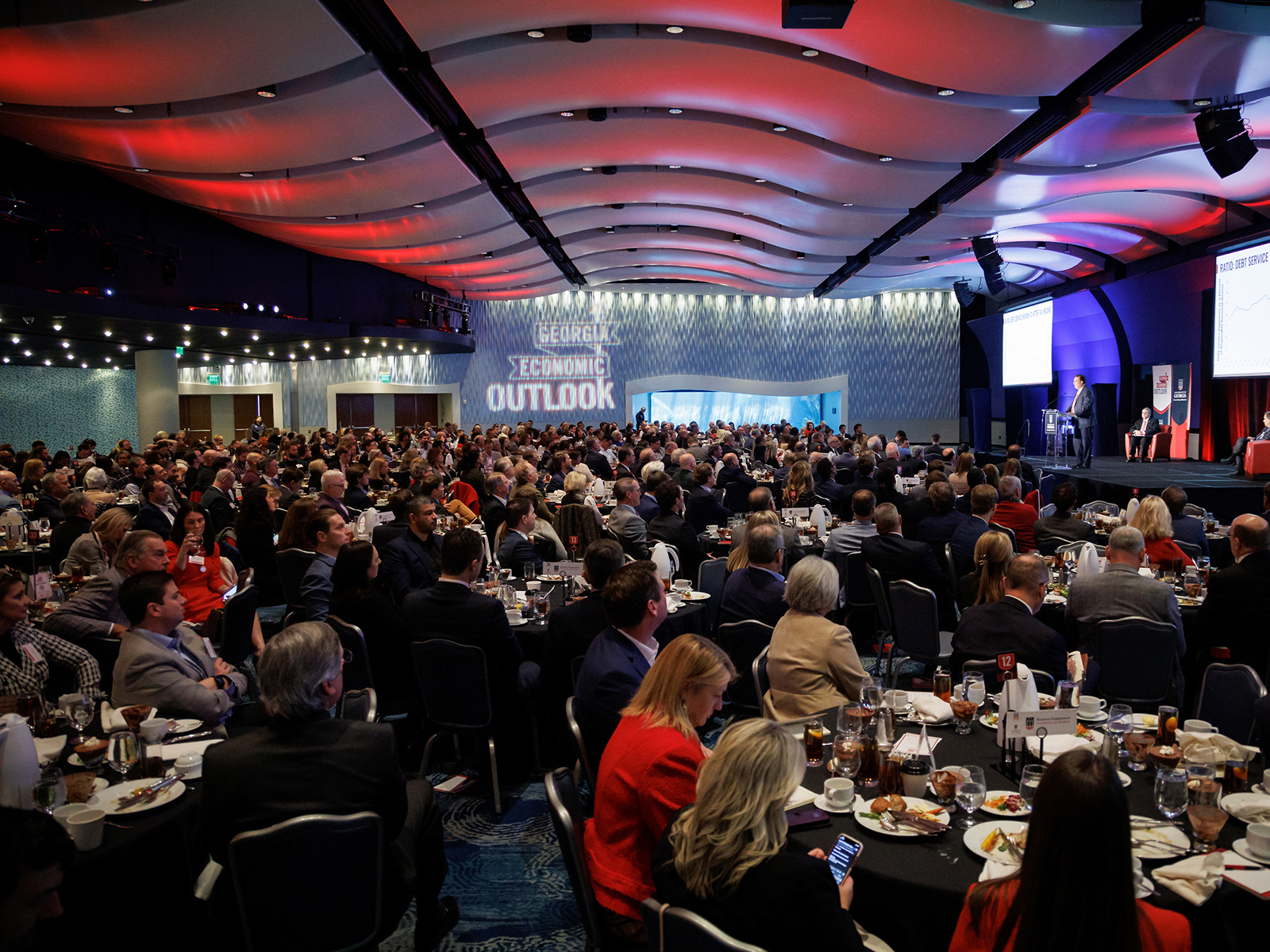 About 600 people seated in the Oceans Ballroom at the Georgia Aquarium with the Georgia Economic Outlook projected on the back wall.