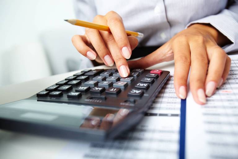 A woman using a calculator to perform calculations.