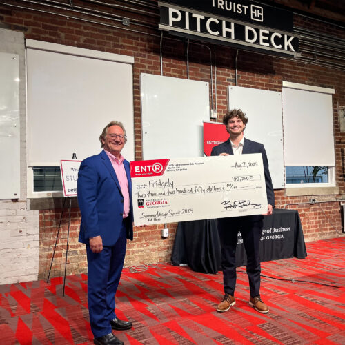 Fridgely wins UGAs 2025 Summer Design Sprint. Design Sprint instructor Don Chambers presents a giant prize check to economics student Gavin Gillespie