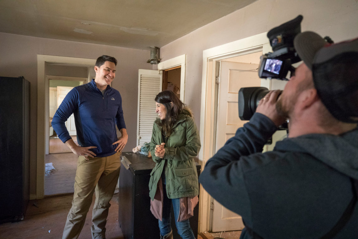Ken and Anita Corsini are filmed by a cameraman inside a house for their HGTV series