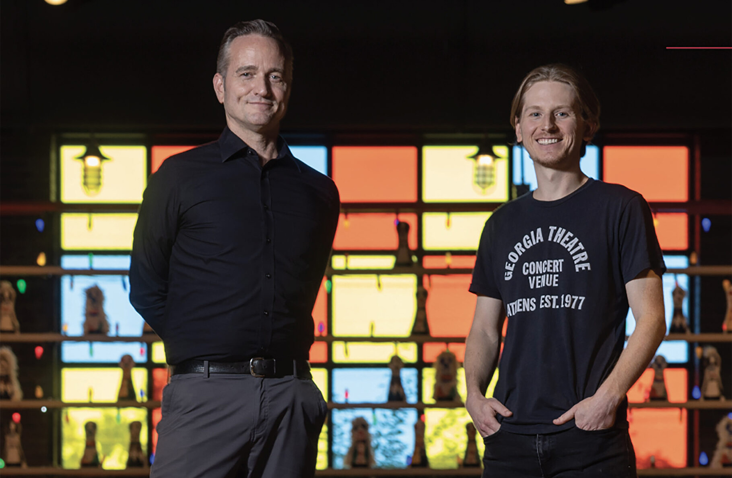 Two men posing in front of stained glass