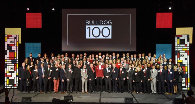 The 2018 Bulldog 100 winners stand together for a photo in front of the Bulldog 100 logo.