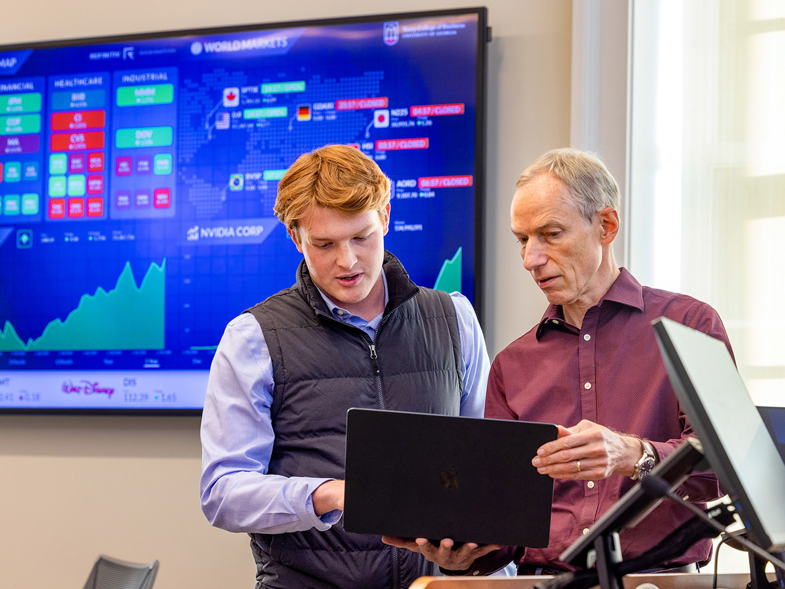 Johannes Kohler works with a student in one of his finance classes