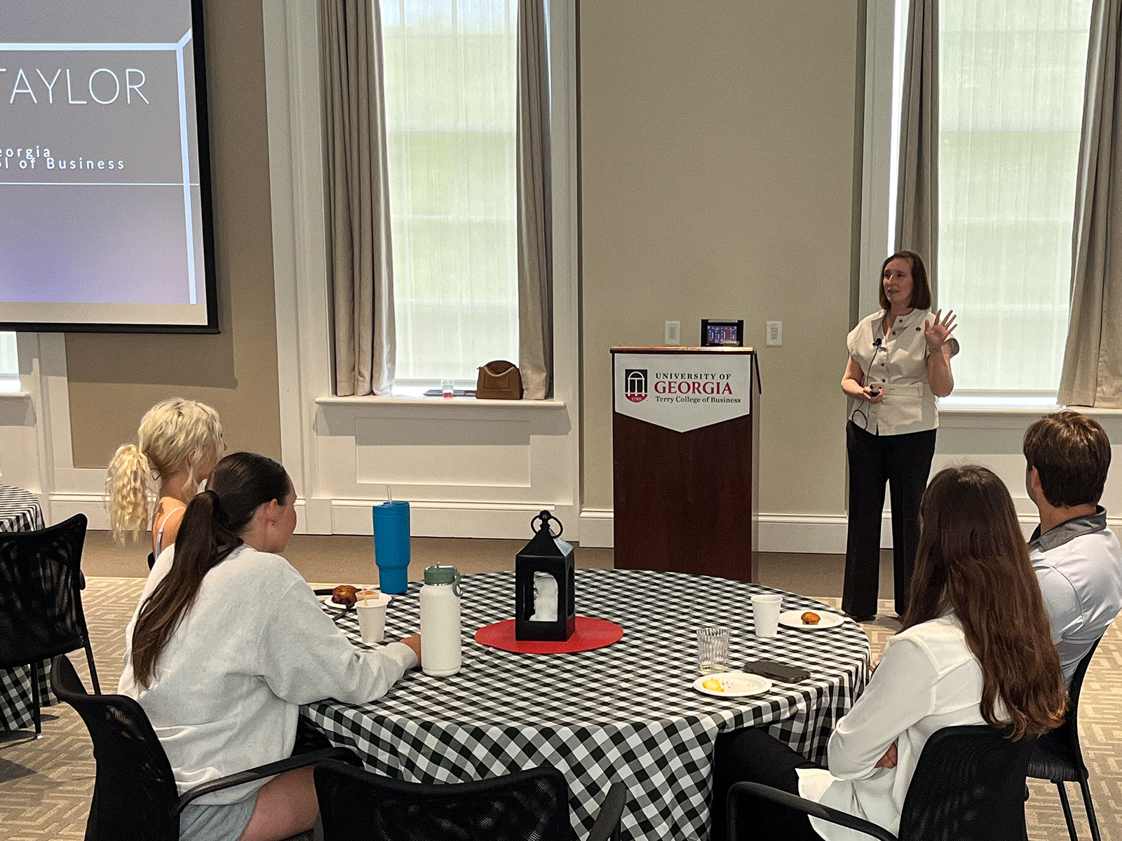 Kristen Taylor stands in front of a crowd of UGA students in the UGA Terry College of Business's Stelling Study.