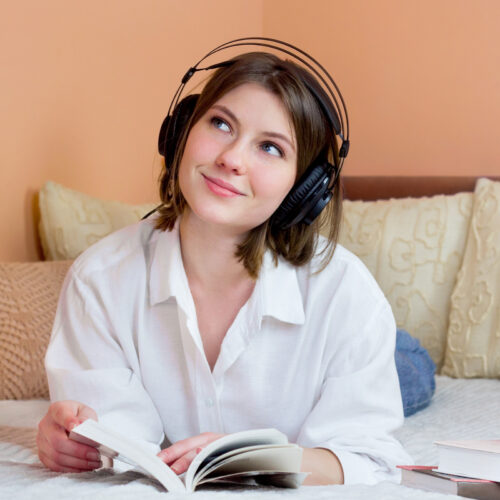 A young professional woman listens to a leadership podcast while relaxing