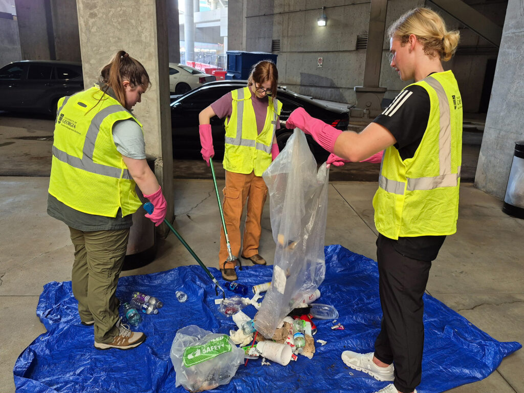 MartaTrashAudit Students sort trash on a blue tarp on the floor of a MARTA station.