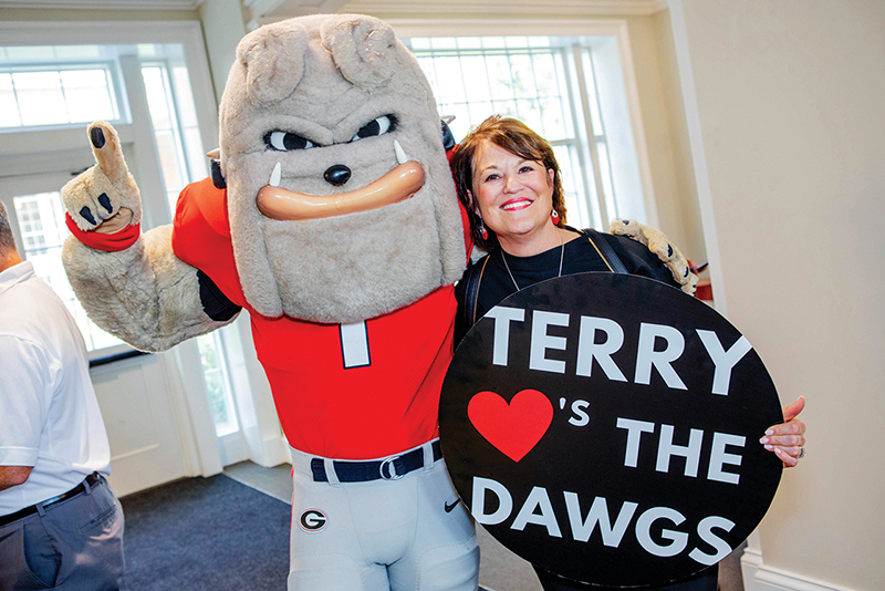 Terry College of Business executive director of development and alumni relations Martee Horne poses for a photo with a University of Georgia mascot