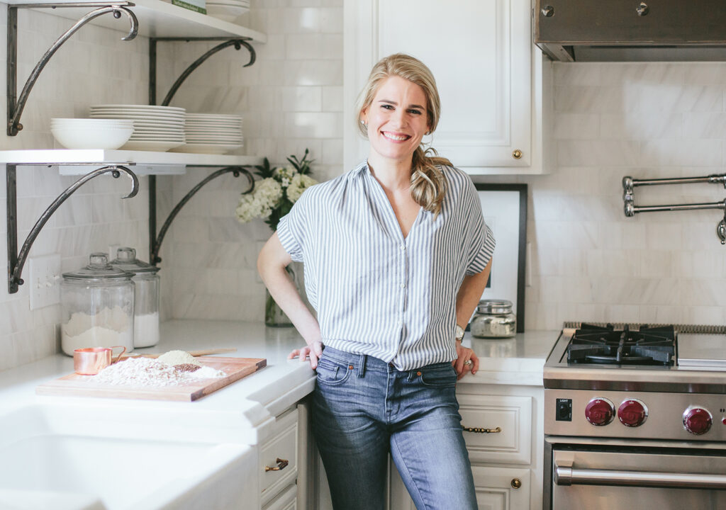Dina Carey poses for a photo in a kitchen.