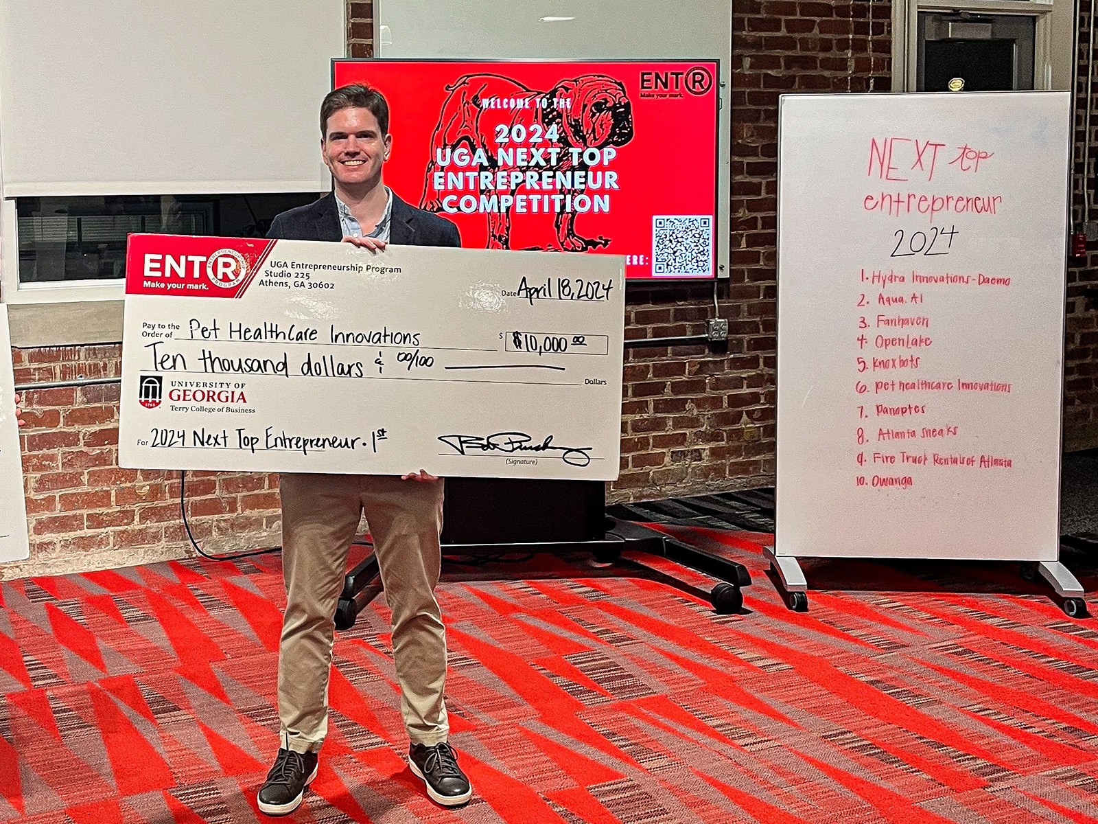 J.D. Thomerson stands with giant novelty check at Studio 225.