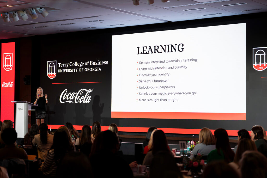 Mary Elizabeth Sadd speaks to the crowd at the Terry College Professional Women's Conference. Her slide is about the importance of learning. 