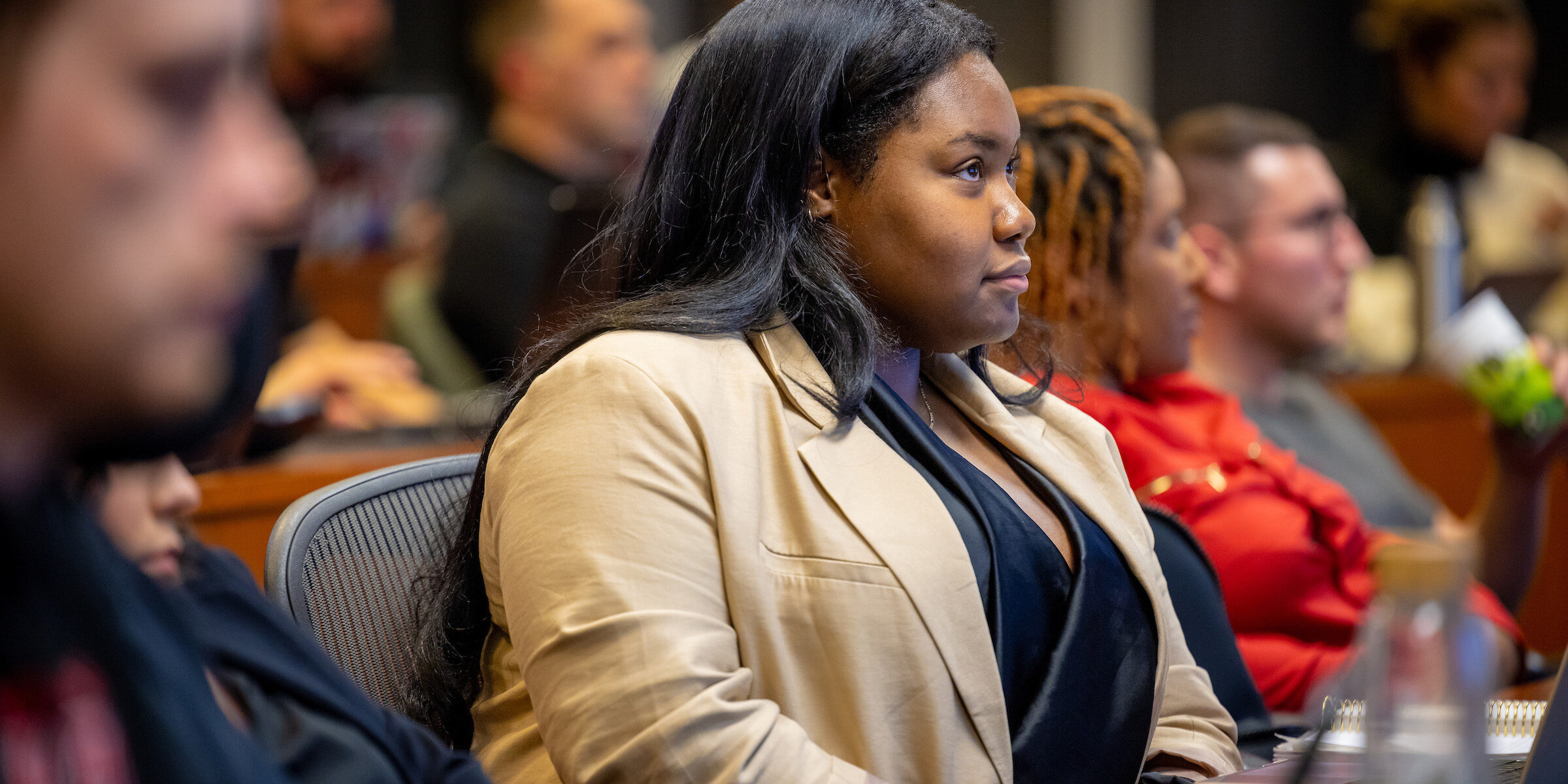 A young-adult African Professional MBA student listens intently to a lecture in class.