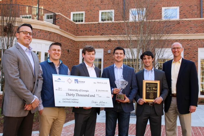Charles DiRocco of Altus Group presents the 2017 Real Confidence University Challenge first-place prize to Terry team members (from left) Tyler Matthews