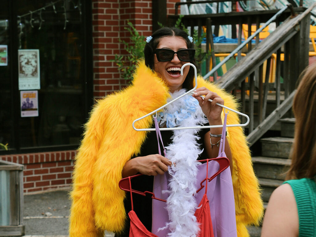 Ruby UGA student Ruby Gagnon tries on a yellow fur coat and laughs