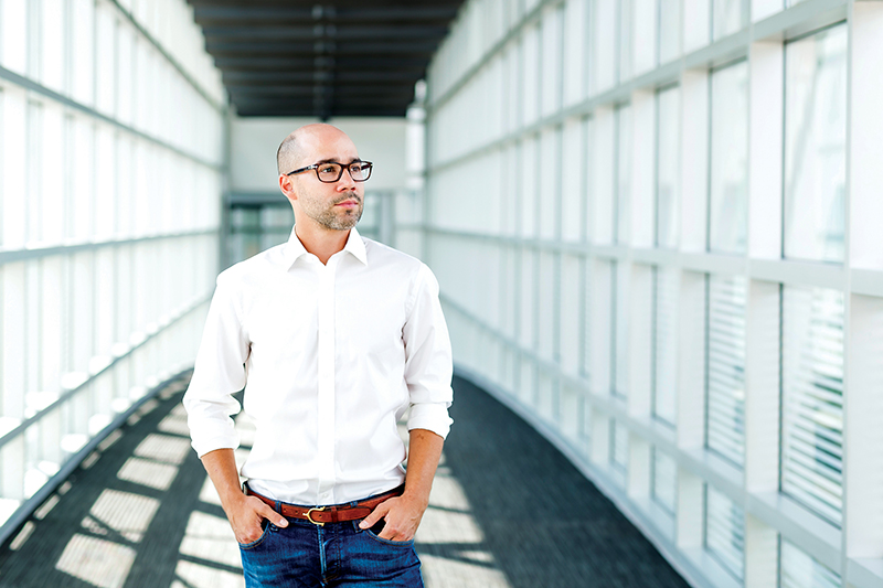 Ryan Leveille stands in front of a walkway.