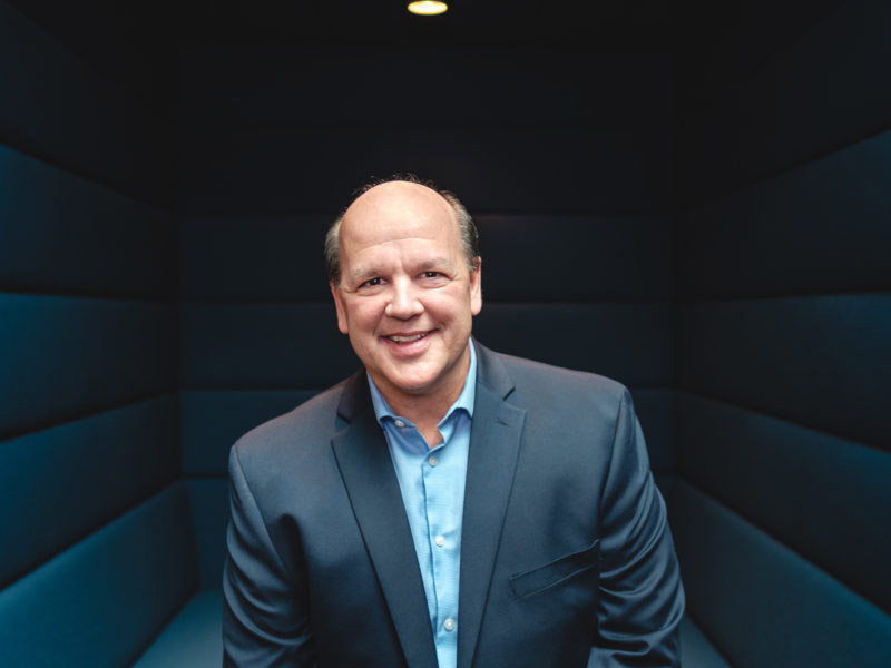 David Salyers poses for a photo in a blue room.