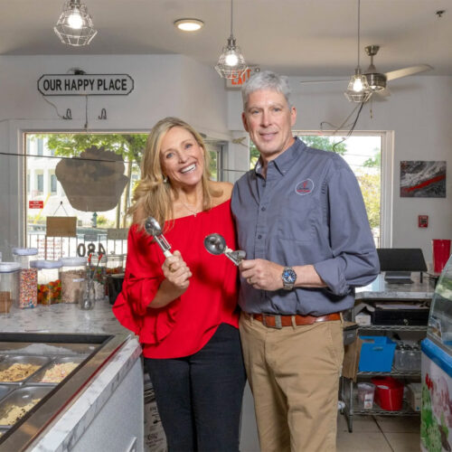 Jennifer and Mike Dollander pose with ice cream scoops in their cookie dough cafe