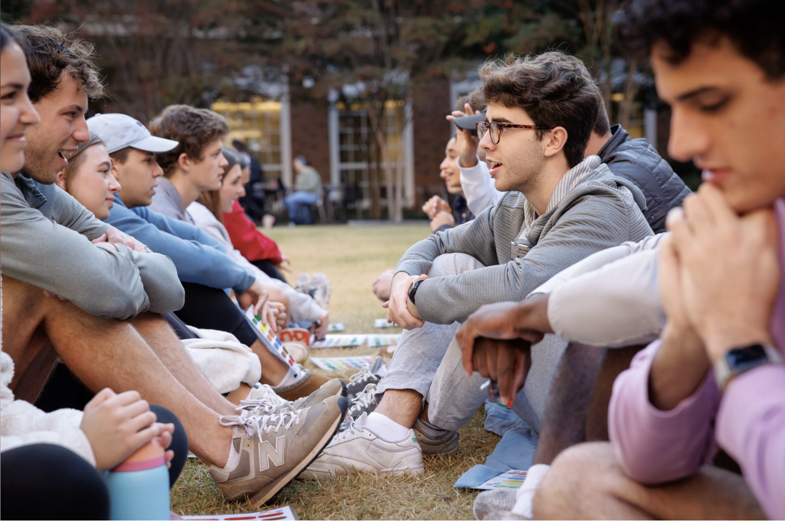 Two lines ILA students sitting on CocaCola Plaza, facing each other and doing a leadership exercise.