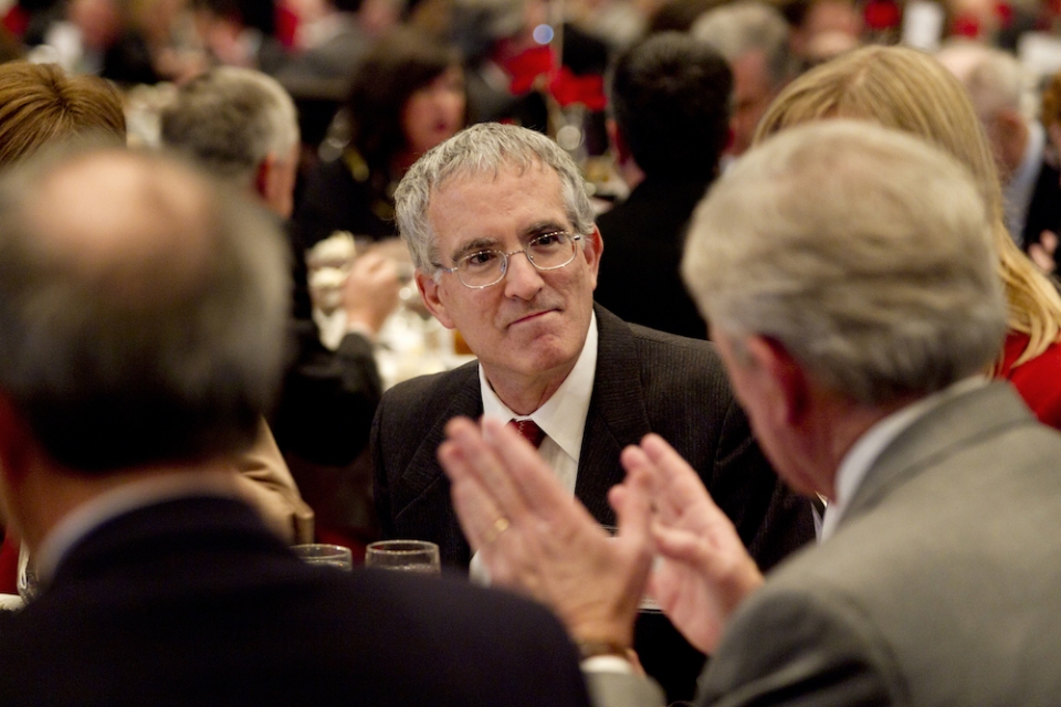 Jeff Humpreys talks with colleagues during a dinner event.