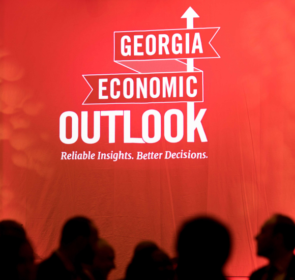 Red background. Silhouettes of people in foreground. "Georgia Economic Outlook".