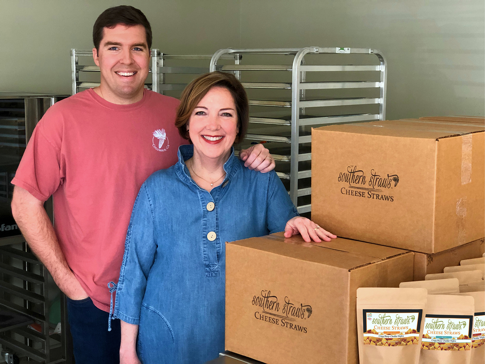 Southern Straws founders Neal Amos and his mother Margaret Amos pose for a photo next to a box containing their company's products.