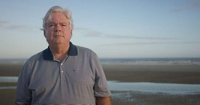 Steve Goodroe poses for a photo in front of the ocean.