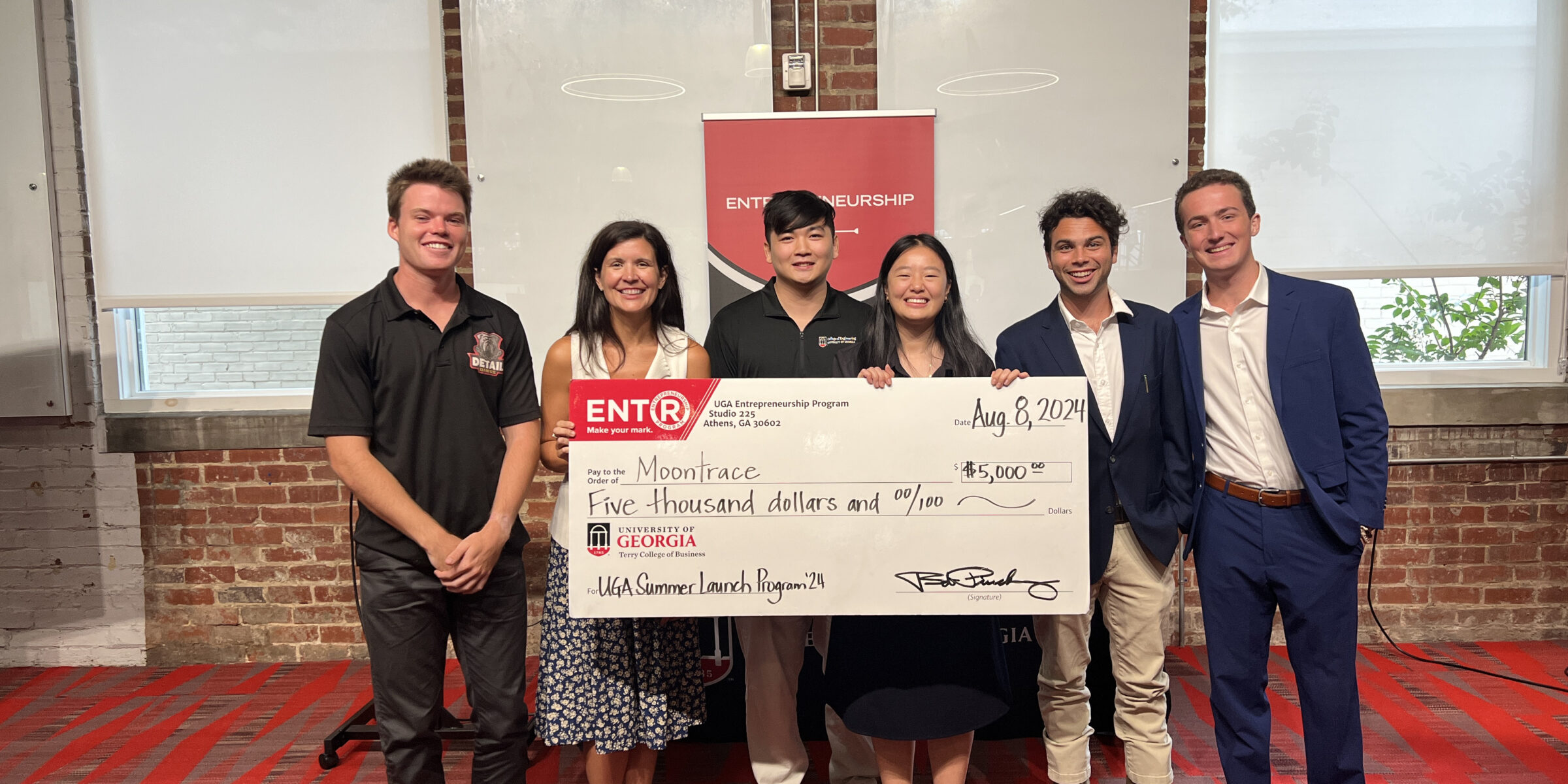 Summer Launch participants, from left, Jack TerHaar, UGA lecturer Cali Brutz, Alex Luu, Jasing Yang, Caleb O'Neil and Landon Stone pose with a giant prize check made out to Yang's company Moontrace.