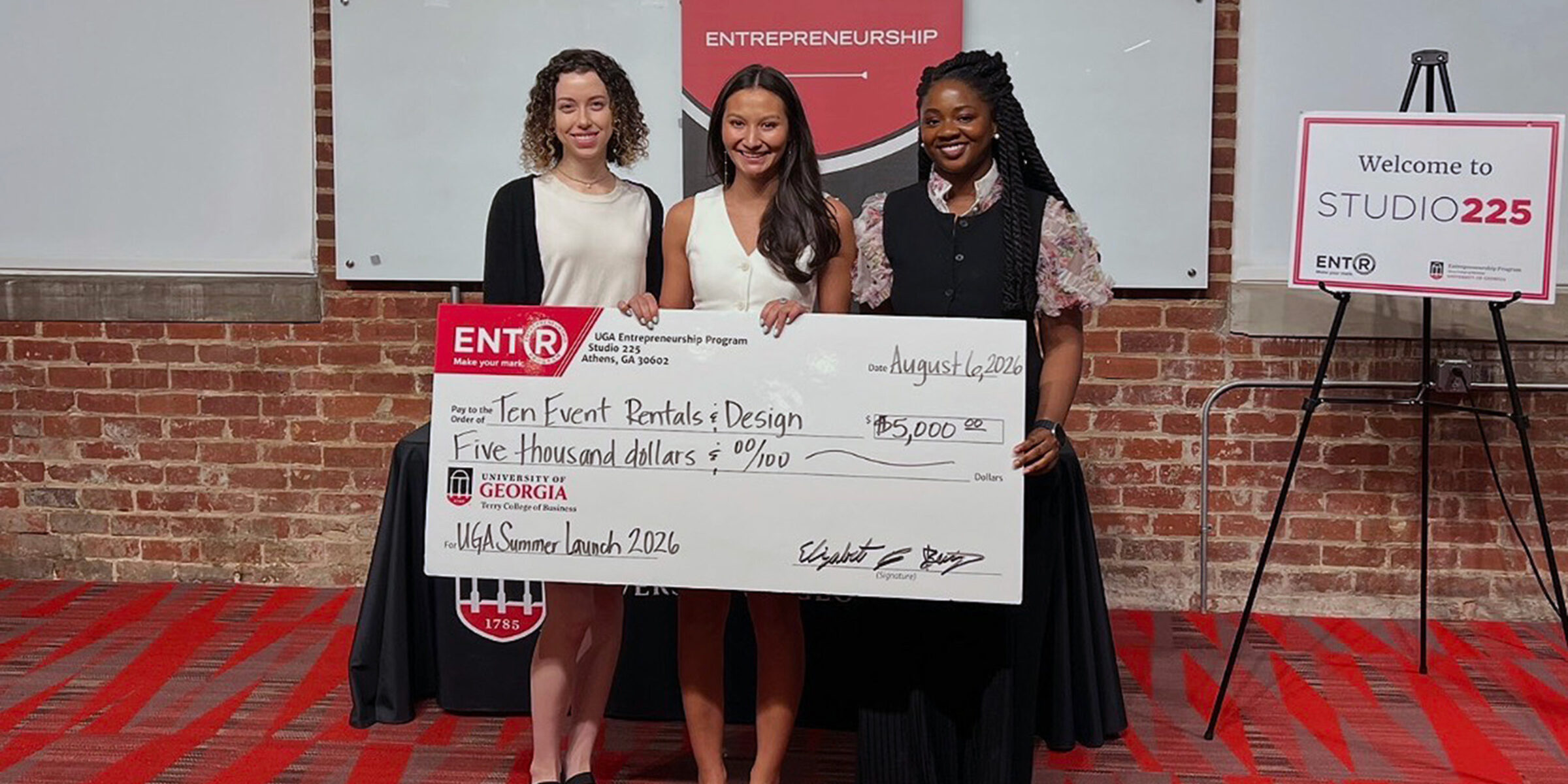 Moren Wallon, far left, and Jane Odum, far right, pose with Tenley Pelissier who holds a novelty prize check for $5000