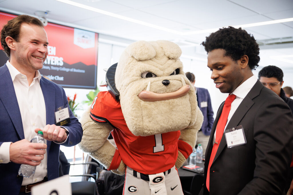 Hairy Dawg with two alumni at the Terry College Young Alumni Summit