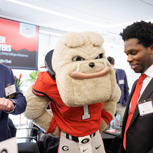 Hairy Dawg with two alumni at the Terry College Young Alumni Summit