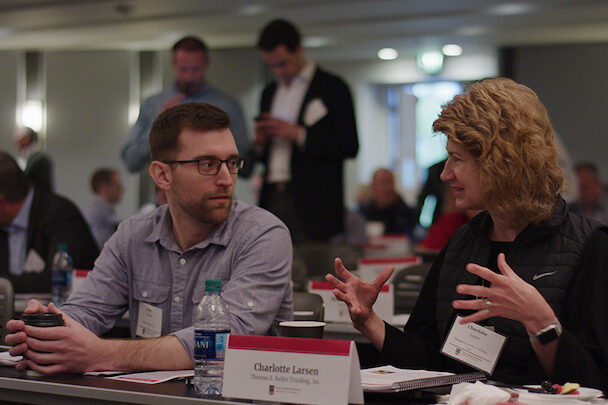 A man and woman engaged in a conversation while seated at a table.