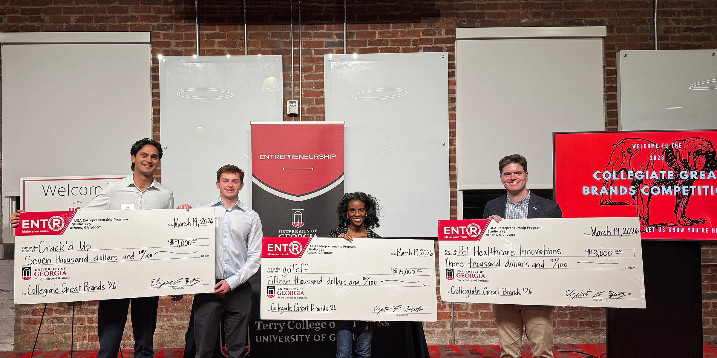 Aiden Silverstein, Nikhil Gandhi, founders of Cracked Up, Soran Mechale, of goTeff and John D. (J.D.) Thomerson, of Pet Health Innovations pose with novelty checks at the Truist Pitch Deck.