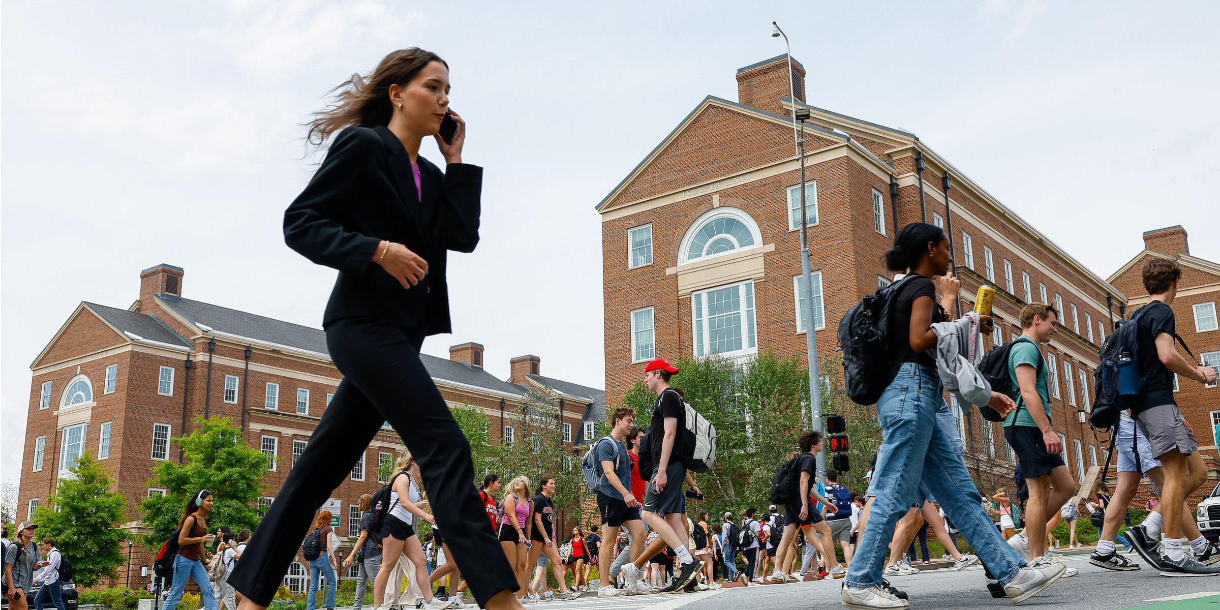 USG graduates stand to earn $1.4 million more thanks to their degrees A college student dressed for an interview crosses a busy intersection on UGA's campus while she talks on a mobile phone.