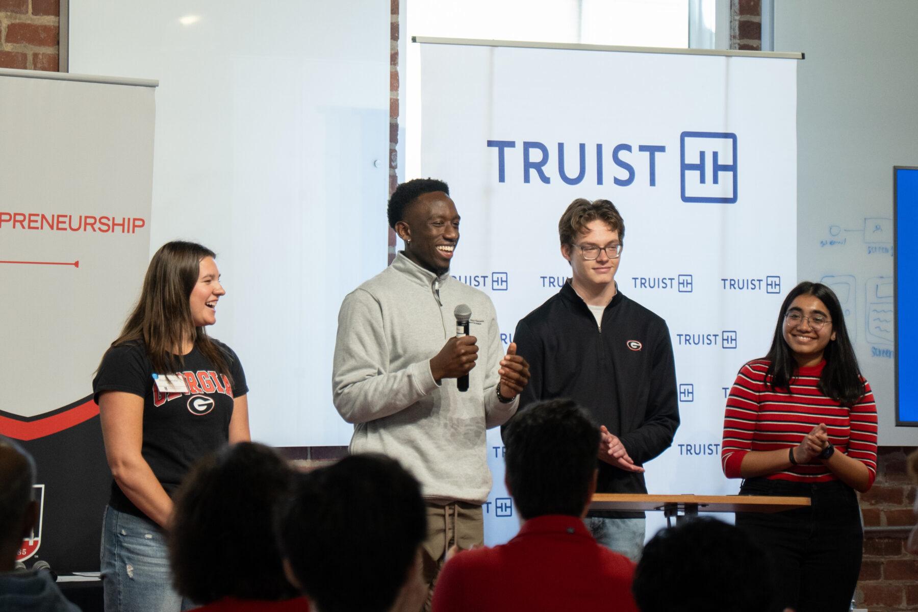 Students pitch a customer service solution to Truist executives during an immersive learning experience at Studio 225