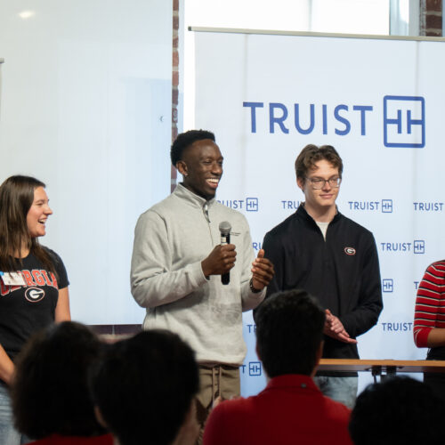 Students pitch a customer service solution to Truist executives during an immersive learning experience at Studio 225