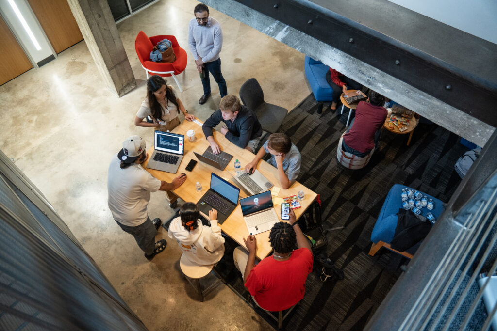Students work around a table at Studio 225, photo shot from above.