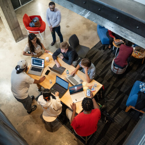 Students work around a table at Studio 225, photo shot from above.