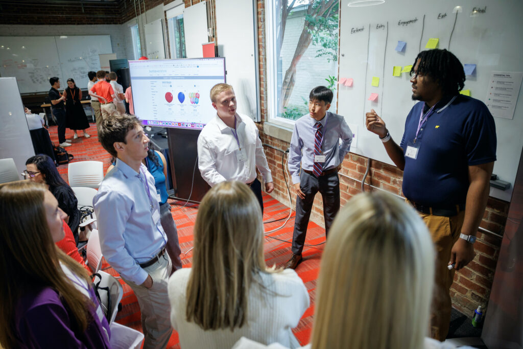 Terry students work at a white board in Studio 225 during the Truist Immersive Learning Experience.