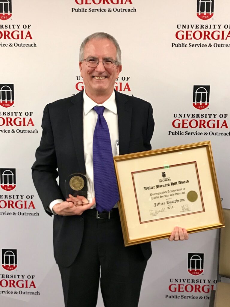 Jeff Humphreys holds his Walter Barnard Hill Award for Distinguished Achievement in Public Service and Outreach award