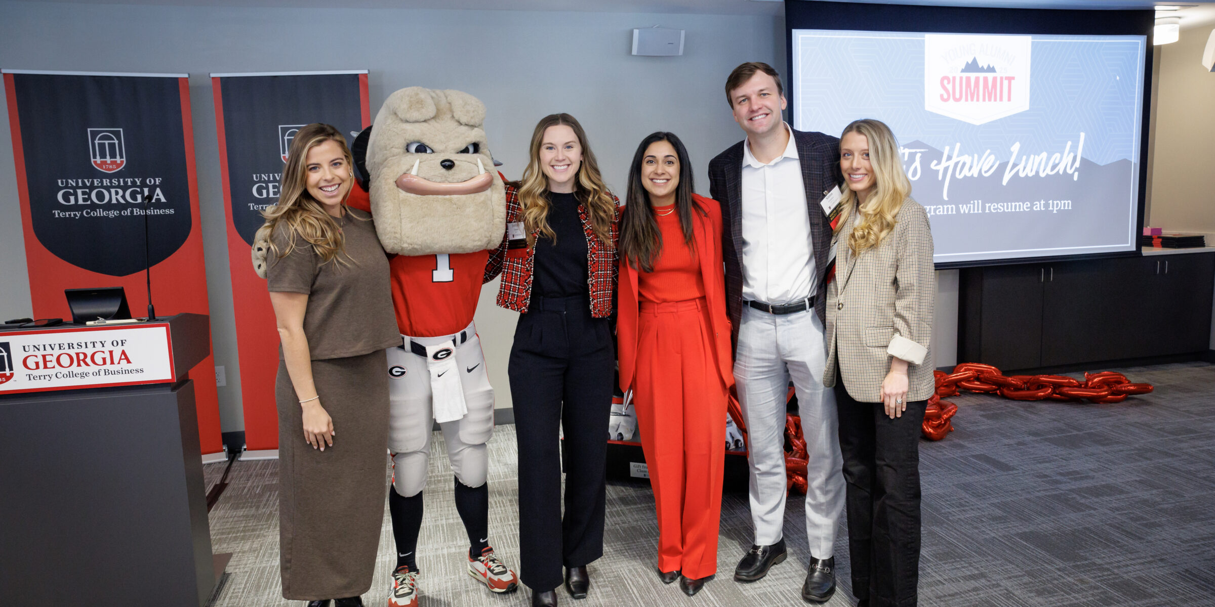 Group of alumni pose for photo with the UGA mascot, Harry Dawg
