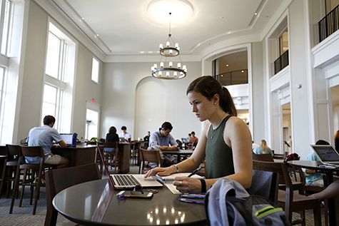 A woman at a table working on her laptop