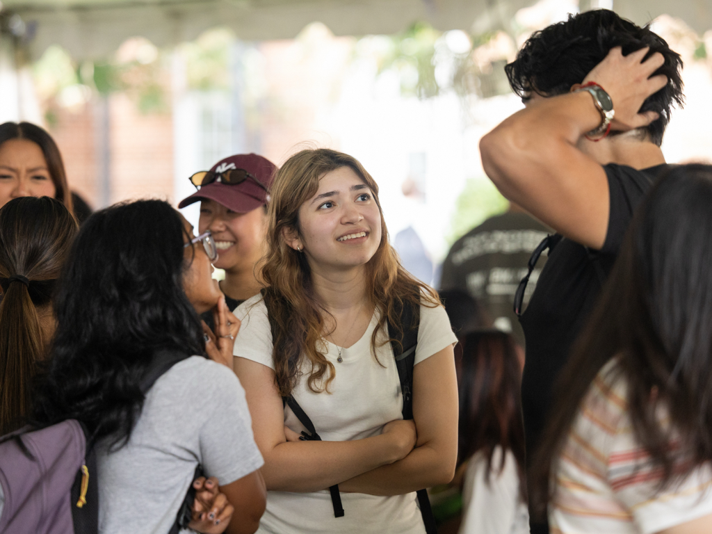 A group of students talk under a tent at the Terry College Welcome Back Block Party.