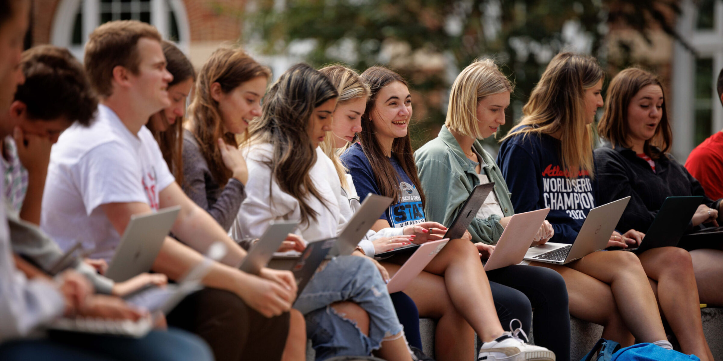 Students attending an outside class on a sunny day.