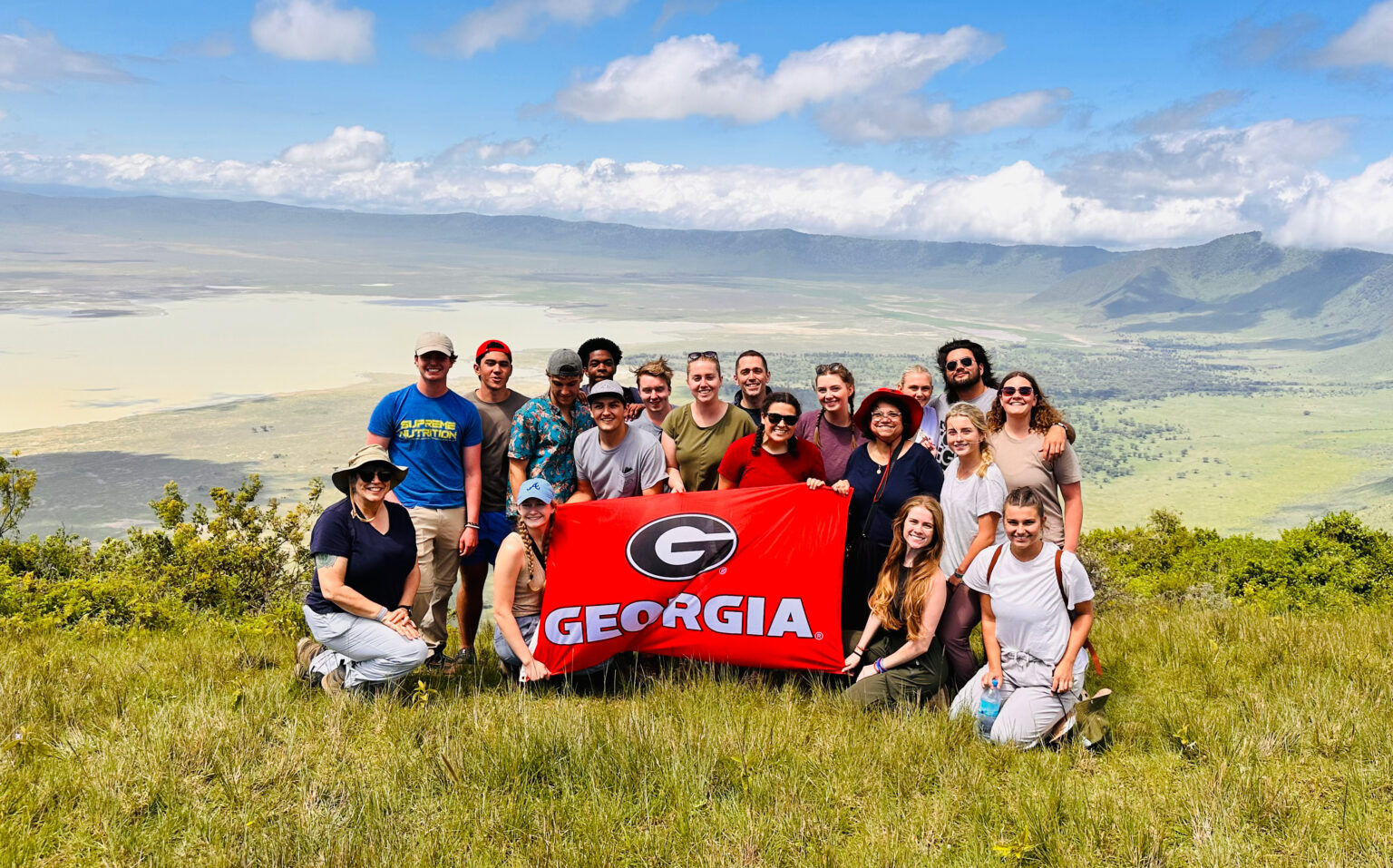 Students on a study abroad trip posing on a mountain ridge with UGA flag. Terry College is launching a project-based business study abroad program in Uruguay.