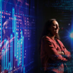 woman poses in dark room with abstract digital backdrop