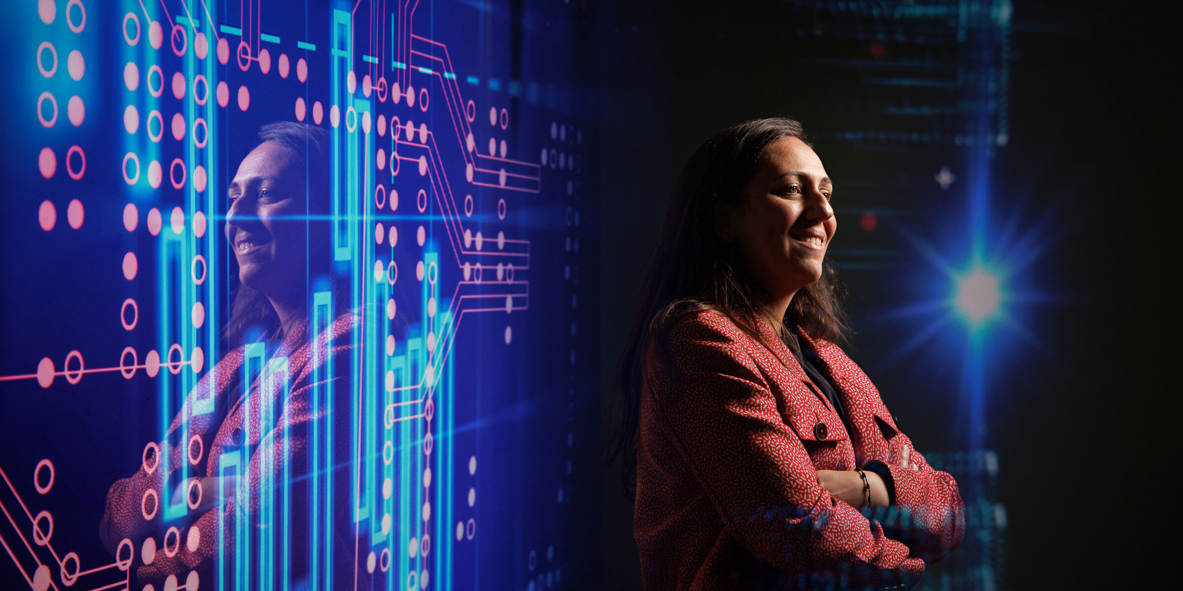 woman poses in dark room with abstract digital backdrop